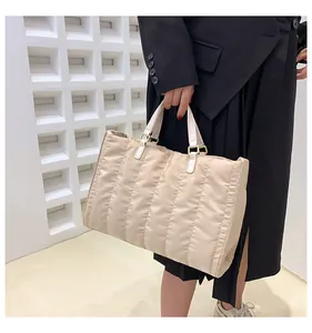 Detail view of the beige quilted tote bag showing its large capacity and soft nylon texture.