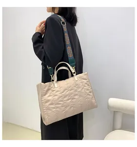 Stylish beige quilted large capacity tote bag with ethnic pattern shoulder strap for women.
