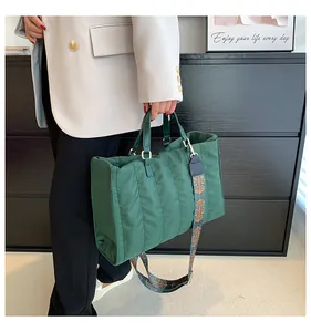 Dettaglio di una grande borsa tote trapuntata verde con tracolla a motivi etnici