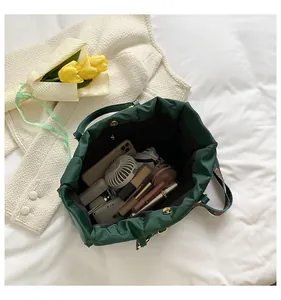 Large capacity dark green puffy tote bag showing interior storage with daily items