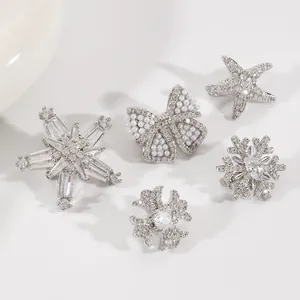 Primer plano de elegantes clips de joyería plateados con circonitas y perlas finas