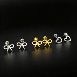 Detail shot of stainless steel stud earrings in bow and heart shapes, gold and silver