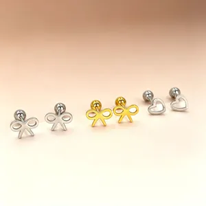 Detailed view of dainty stainless steel bow and heart stud earrings in gold and silver