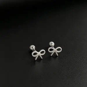 Close-up of minimalist stainless steel bow-shaped stud earrings with silver finish
