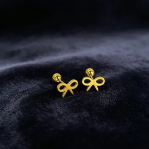 Detailed close-up of gold-plated stainless steel bow-knot stud earrings on velvet