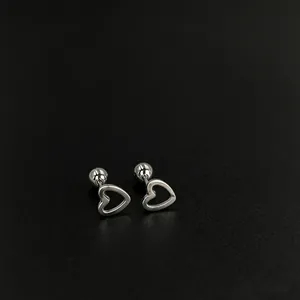 Exquisite close-up detail of silver stainless steel hollow heart-shaped ear bone studs
