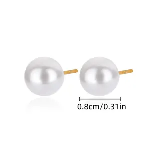 Détail des boucles d'oreilles perles blanches de 0,8 cm montrant la taille et la forme ronde.
