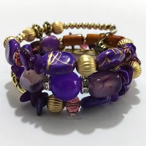 Close-up of Bohemian multi-layer beaded bracelet with purple stones and gold accents