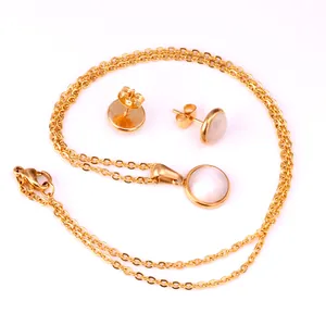 Détail de parure collier et boucles d'oreilles en acier doré avec pendentifs oeil de chat