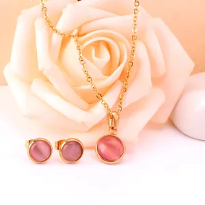 Gros plan de l'ensemble collier et boucles d'oreilles avec pendentif œil de chat rose doré