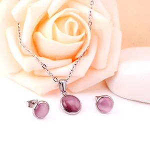 Détail d'un ensemble collier et boucles d'oreilles en acier avec pierres œil de chat roses
