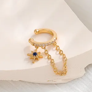 Detailansicht einer goldenen Stern-Ohrmanschette mit Kette und blauem Kristallbesatz