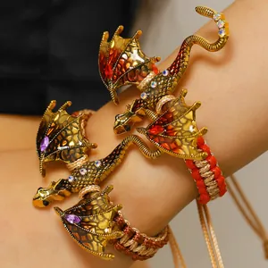 Close-up detail of vintage dragon braided bracelets featuring colorful enamel wings