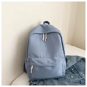 Close-up of minimalist light blue travel backpack with white rope zipper pulls