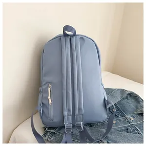 Back view of minimalist light blue backpack with adjustable straps and zipper pocket
