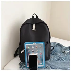 Close-up of minimalist black backpack with tablet and phone for size reference
