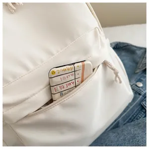 Close-up detail of white minimalist Japanese style girl backpack showing zipper pocket