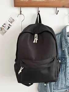 Minimalist black Japanese-style backpack with white rope zipper pulls for daily use