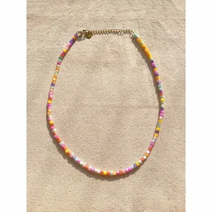 Primo piano di perline a cubo in conchiglia naturale colorata su una collana stile boho chic