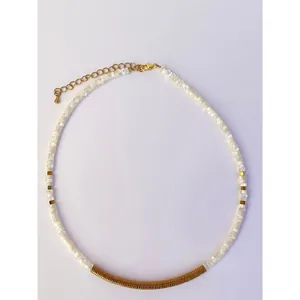 Primo piano di collana in perline di conchiglia bianca con barra in metallo dorato