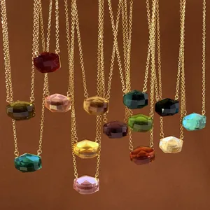 Detailed view of multiple multi-colored irregular cut gemstone necklaces on gold chains