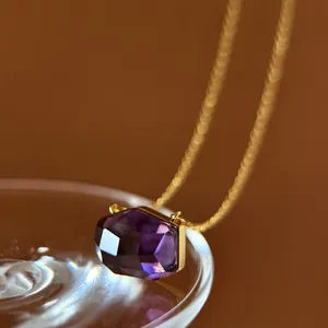 Macro view of irregular faceted purple crystal pendant necklace with an elegant gold chain
