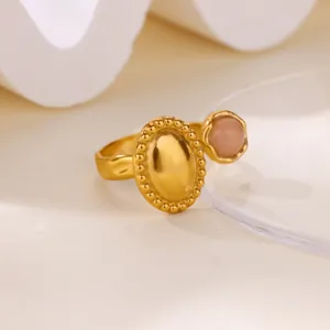 Detailed view of a vintage gold-plated stainless steel open ring with a pink stone accent