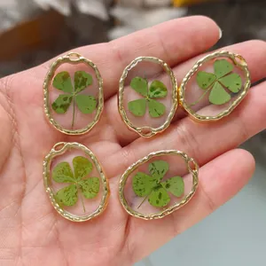 Gros plan de boucles d'oreilles en résine avec vrais trèfles à quatre feuilles