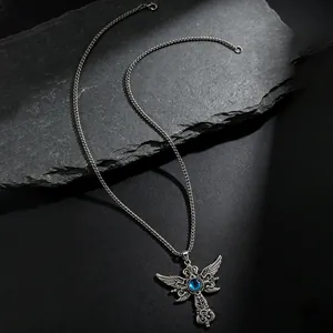 Detalle de collar gótico con cruz de alas de ángel y piedra preciosa azul central