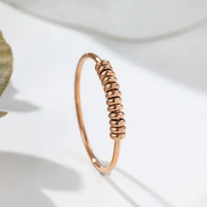 Makrodetail eines roségoldenen Anti-Angst-Rings aus Titanstahl mit Drehkugeln
