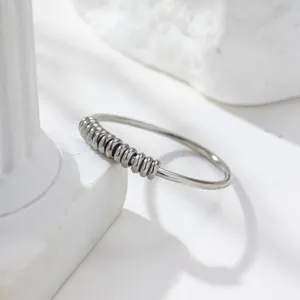 Detailansicht eines Anti-Angst-Rings aus Edelstahl mit beweglichen Perlen auf weißem Stein.