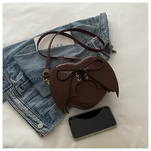 Brown heart-shaped crossbody bag with bat wings and lace-up detail for Halloween