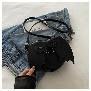Close-up of black heart-shaped bag with bat wings and lace-up detail
