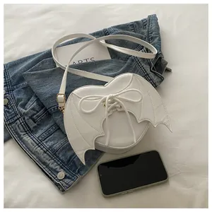 Detailed view of white bat wing crossbody bag featuring lace-up design and cute bow