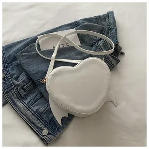 Detailed close-up view of a white heart-shaped crossbody bag with cute bat wing design