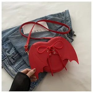 Red heart-shaped crossbody bag featuring creative bat wings and lace-up design details.
