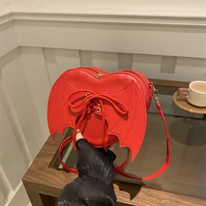 Red heart-shaped crossbody bag with bat wings and lace-up detail for Halloween