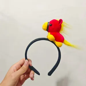 Detail view of cute red and yellow plush horse toy attached to a black headband