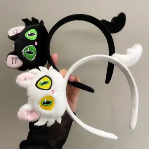 Cute plush cartoon cat headbands in black and white with quirky embroidered eyes and tails