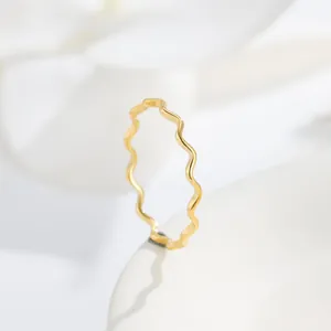 Macro view showing the delicate wavy design of this gold minimalist stainless steel ring