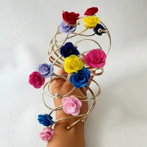 Nahaufnahme eines eleganten goldenen Spiral-Armreifs mit bunten 3D-Stoffrosen