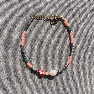 Vue détaillée du bracelet en pierre naturelle colorée avec perle d'eau douce et cœur rouge