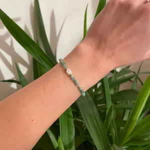 Détail d'un élégant bracelet en perles d'eau douce et cristaux verts facettés au poignet