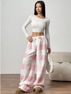 Cozy pink and white checkered plush wide-leg lounge pants worn by a model