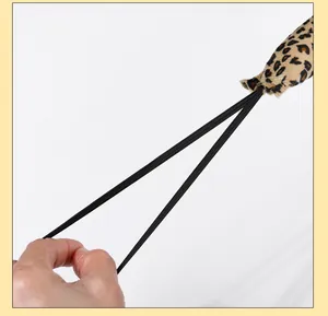 Close-up detail of plush leopard print tail showing elastic attachment for costume accessories