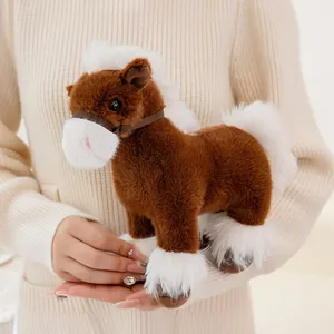 Close-up view of a soft brown and white plush horse toy held in hands, cozy details.