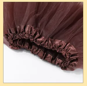 Close-up detail of a brown mesh tutu skirt showing the elastic satin waistband texture