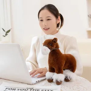 Realistic brown and white pony plush toy placed next to a laptop on a desk