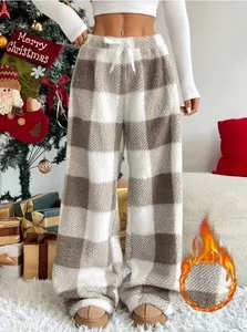 Detail view of cozy plaid fleece trousers for winter with festive Christmas background