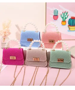 Vista detallada de mini bolsos de gelatina en colores caramelo con asas de perlas
